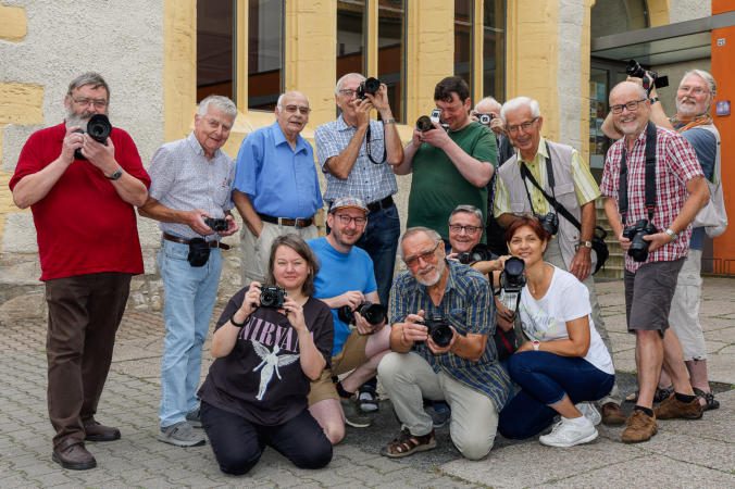 Gruppe von Fotografiebegeisterten, die mit Kameras posieren.