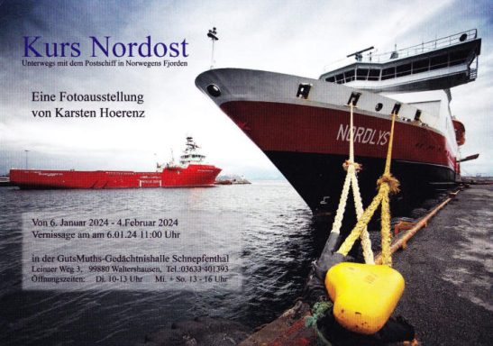 Rotes Schiff am Kai, mit einem weiteren Schiff im Hintergrund und Wolken am Himmel.
